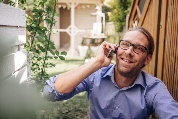 Homem ao telefone no jardim