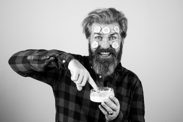 Homem aplicando creme facial Homem facial Homem engraçado com uma máscara de argila