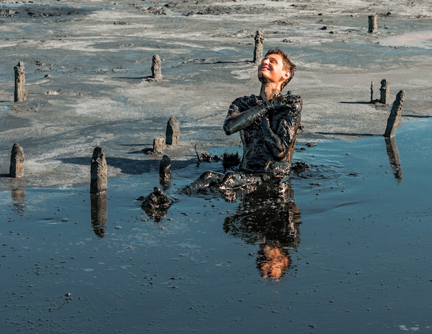 Homem aplicando lama curativa em seu corpo