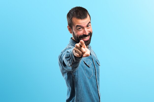 Foto homem apontando para a frente em fundo colorido