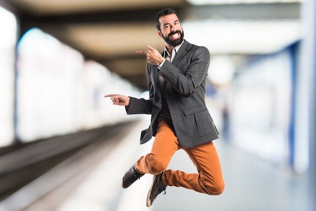 Homem apontando para o lateral em fundo não focado