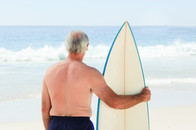 Homem aposentado com sua prancha de surf