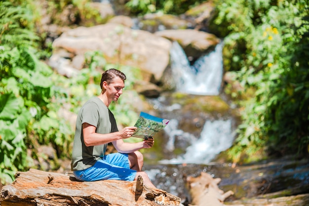 Homem apreciando a vista da cachoeira na selva