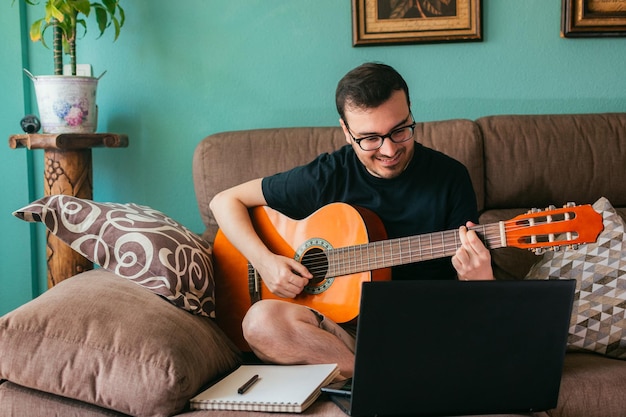 Homem aprende a tocar guitarra em casa