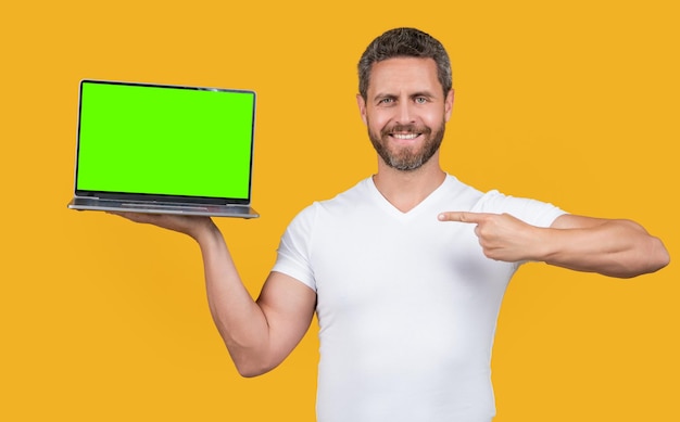 Homem apresentando laptop portátil no estúdio apontando dedo homem mostrando laptop portátil