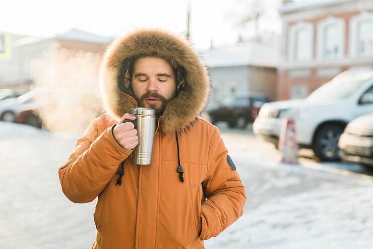 Foto homem aquecendo-se com bebida quente em manhã de inverno frio ao ar livre copiar o espaço conforto rotina e