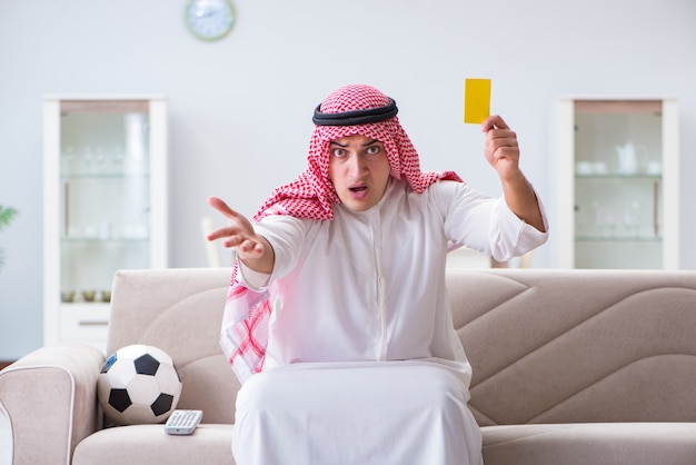 Homem árabe assistindo futebol de esporte na tv