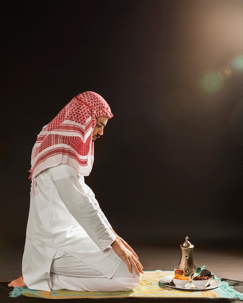 Foto homem árabe com kandora rezando