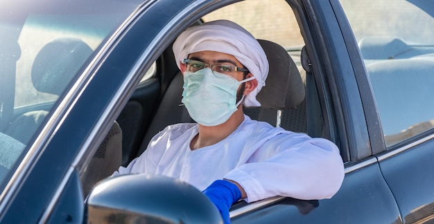 Homem árabe dirigindo um carro na pandemia