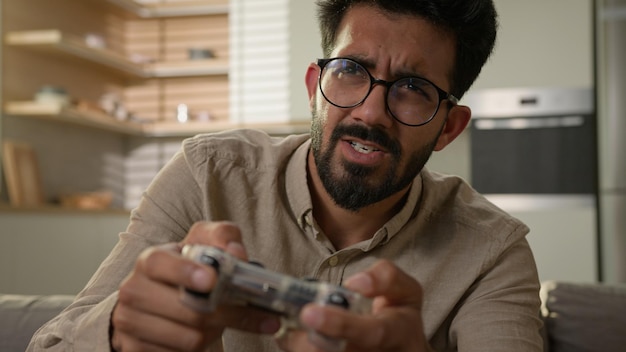 homem árabe indiano homem étnico divertir-se no sofá sofá jogar videogame on-line consola de TV inteligente virtual