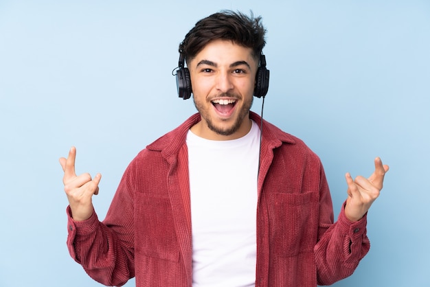 Homem árabe ouvindo música fazendo gestos de rock