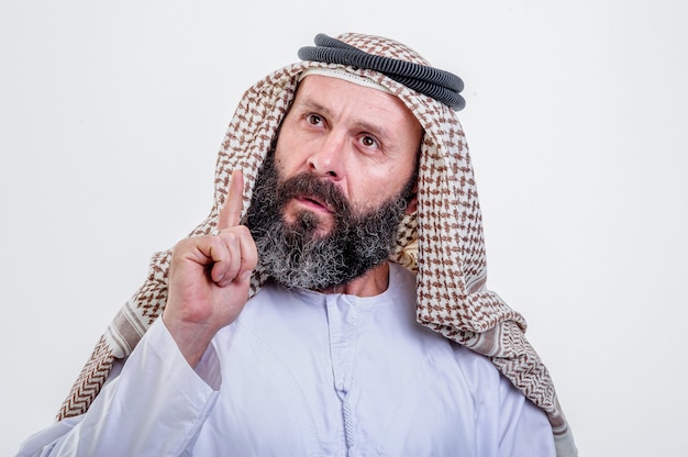 Homem árabe pensando posando em fundo branco.