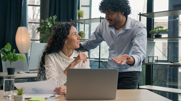 Homem árabe treinador de negócios ajudando mulher hispânica estagiário empresário mentor consultor colega