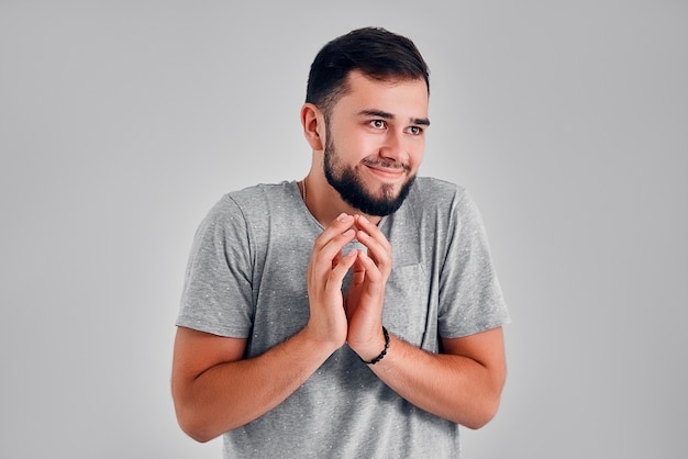 Homem ardiloso tentando traçar algo isolado em fundo cinza. Sentimento de expressão facial de emoção humana negativa