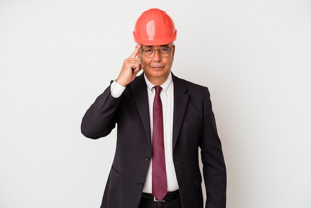 Homem arquiteto sênior isolado apontando o templo com o dedo, pensando, focado em uma tarefa.