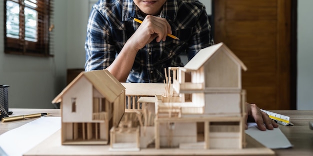 Foto homem arquiteto trabalhando com plantas para engenheiro de plano arquitetônico esboçando um conceito de projeto de construção