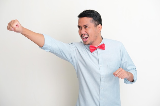 Homem asiático adulto usando gravata borboleta vermelha fazendo pose de mosca com expressão animada
