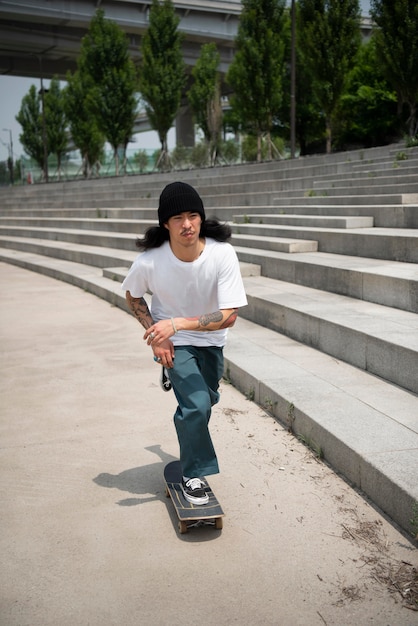 Homem asiático andando de skate na cidade