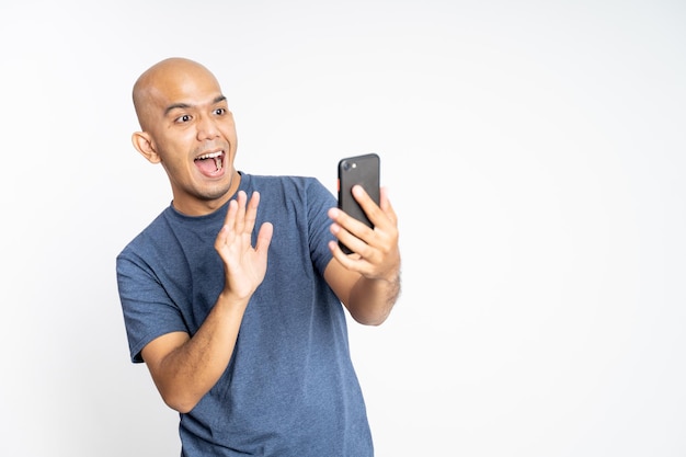 Homem asiático animado acenando com a mão ao fazer videochamada