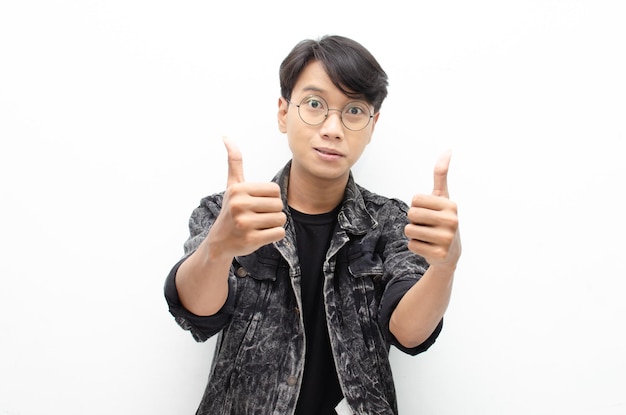 homem asiático atraente vestindo jaqueta jeans sorrindo alegremente e dando polegares para cima como elogio