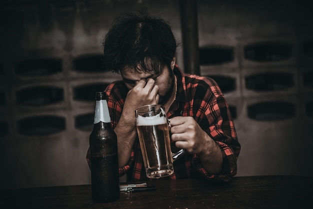 Homem asiático bebe vodka sozinho em casa à noitePovo da TailândiaEstresse o conceito de bêbado
