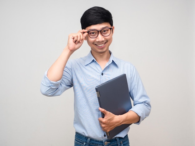 Homem asiático bonito segura sorriso de laptop e posando inteligente isolado