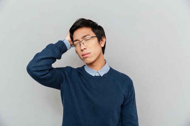 Homem asiático cansado. olhos fechados