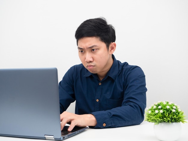 Homem asiático com a intenção de trabalhar em casa com seu laptop na mesa