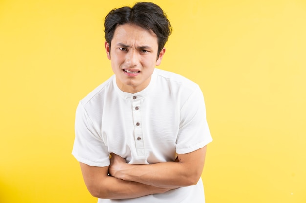 Homem asiático com dor de estômago no azul