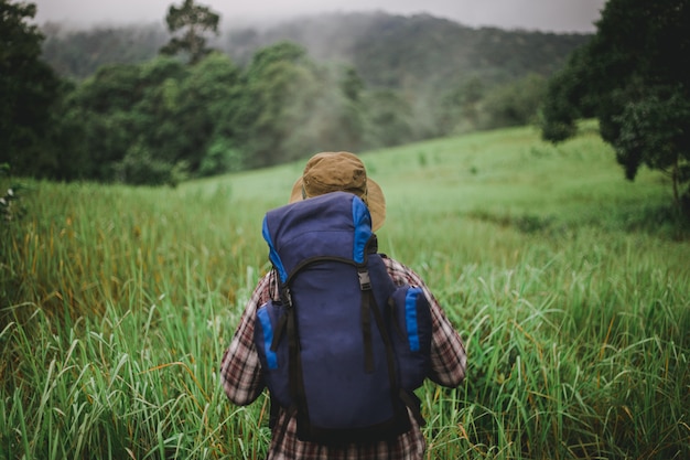 Homem asiático com mochila e chapéu na montanha