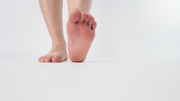 Homem asiático com os pés descalços é isolado no fundo branco.