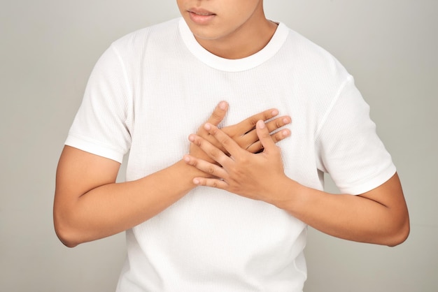 Homem asiático com peito apertado de fundo branco de ataque cardíaco Conceito de pessoa doente