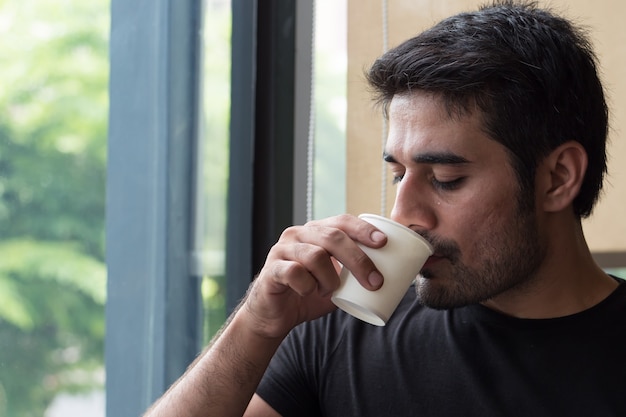 Homem asiático com sede bebendo água