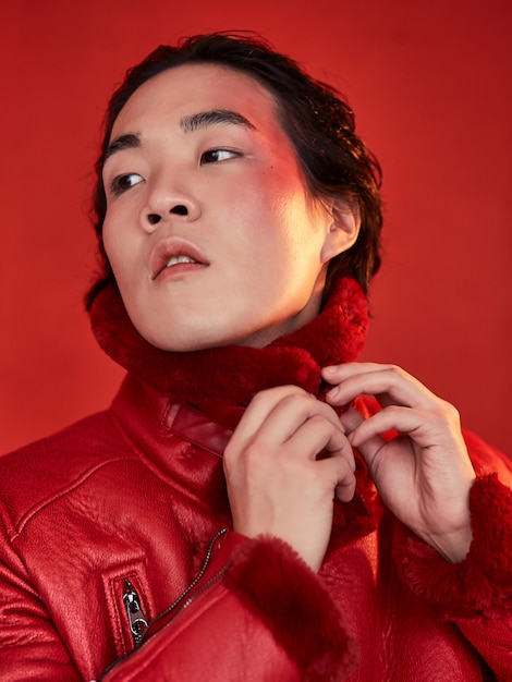 Homem asiático em roupas vermelhas em um espaço vermelho