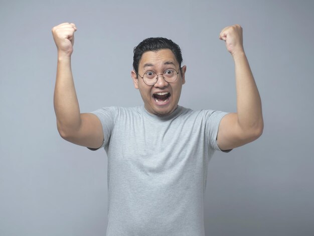 Homem asiático engraçado mostra expressão de felicidade surpresa