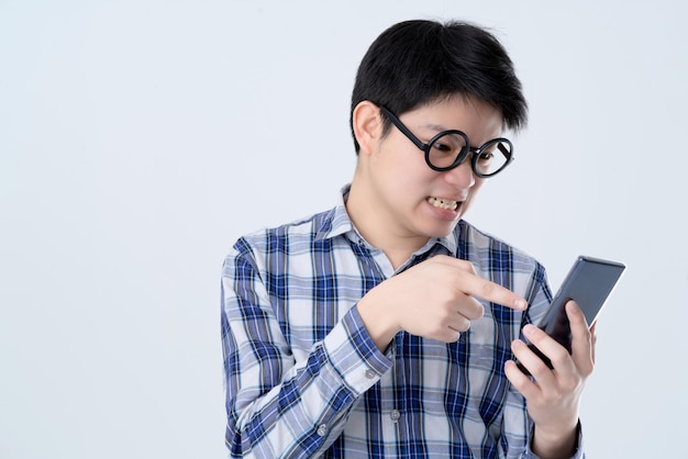 Homem asiático estressante grita no smartphone com fundo branco de raiva e emoção