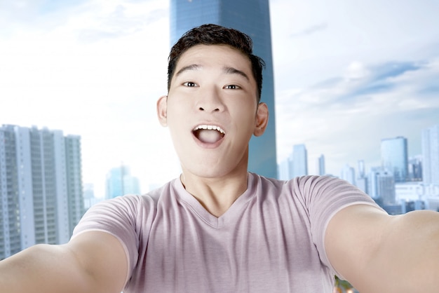Homem asiático fazendo selfie com seu smartphone