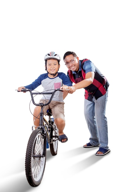 Homem asiático guiando seu filho andando de bicicleta