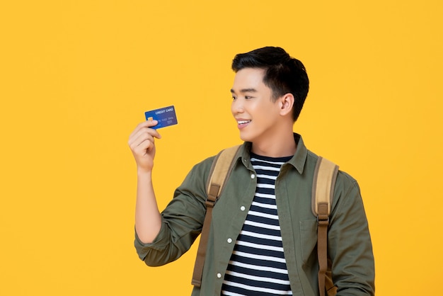 Foto homem asiático jovem turista segurando o cartão de crédito