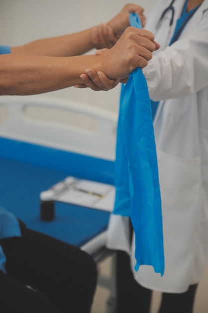 Foto homem asiático mais velho fazendo fisioterapeuta com apoio da enfermeira idoso sênior sentado no sofá na sala de estar usando exercícios de treino com halteres para paciente com cuidador em cuidados de enfermagem