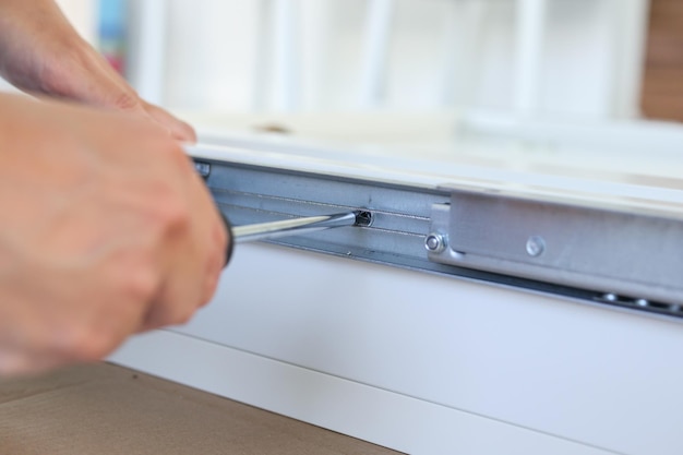 Homem asiático montando móveis de mesa branca em casa