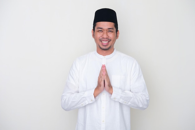 Homem asiático muçulmano sorrindo para cumprimentar durante a celebração do Ramadã