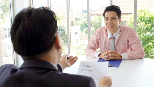 Homem asiático na entrevista de emprego no fundo do escritório