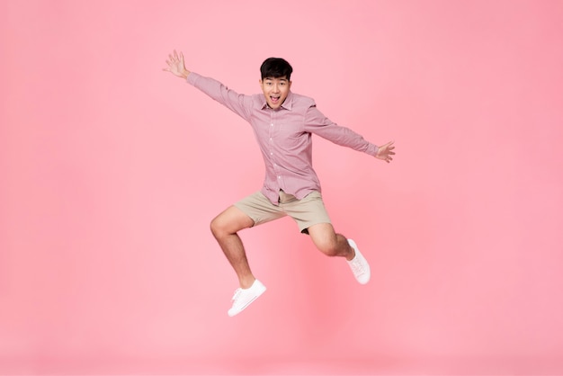 Homem asiático novo feliz energético que salta
