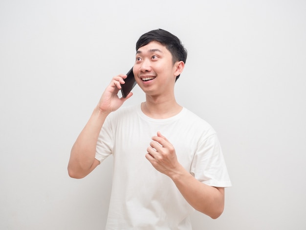 Homem asiático ouvindo boas notícias com cara feliz de callphone em fundo branco