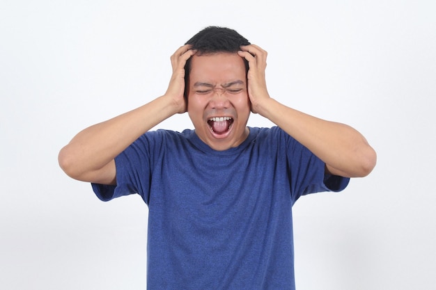 Foto homem asiático segurando a cabeça franzindo a testa de preocupação gritando homem puxando o coração por preocupação tristeza