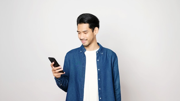 Homem asiático segurando um celular e sorrindo