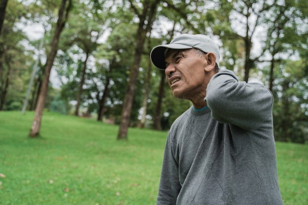 Foto homem asiático sênior com dor nas costas e pescoço