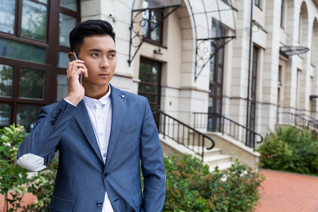 Homem asiático sério no telefone