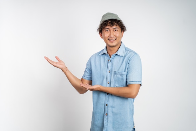 Homem asiático sorrindo com as duas mãos apresentando algo